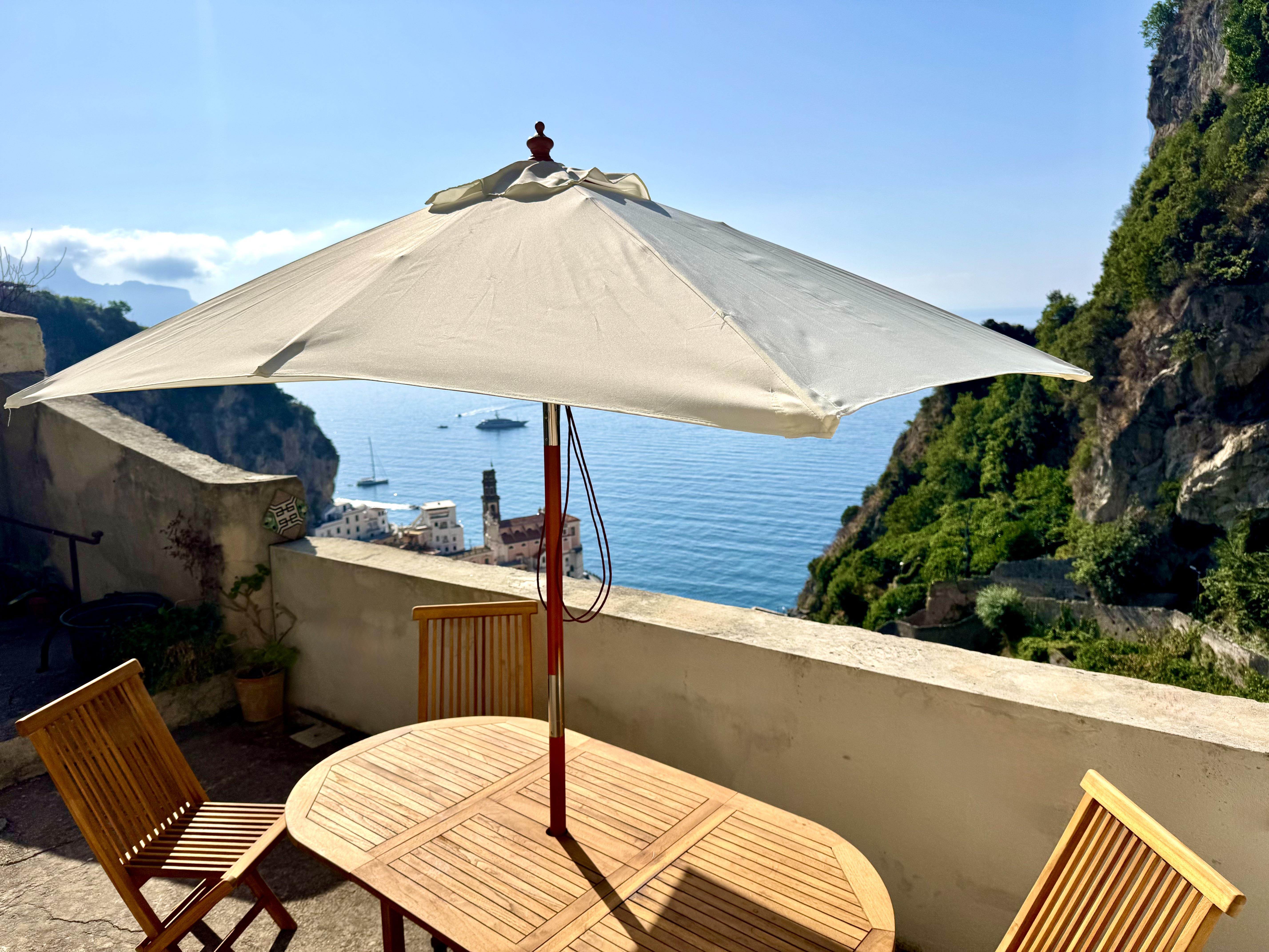 Terrazzo panoramico con tavolo e ombrellone sulla costa